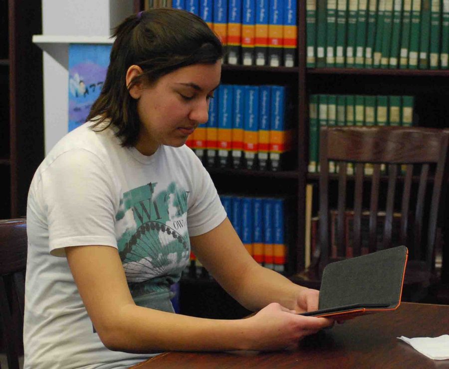 A student reads a book from one of the ten Amazon Kindles in the RHS library. -photo by Nursena Acar