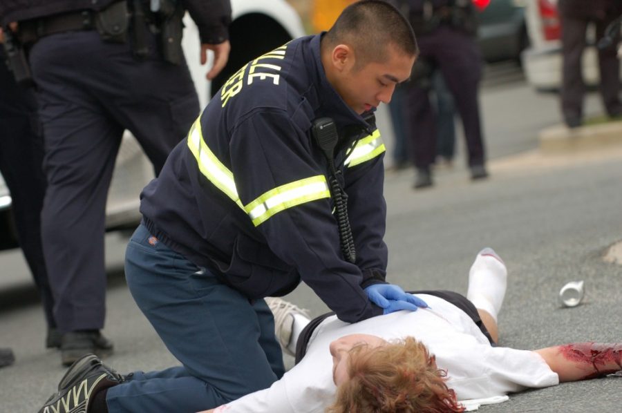 EMT worker Alex Sha attempts to perform CPR on the injuried pedestrian during the EFMs fake car accident.