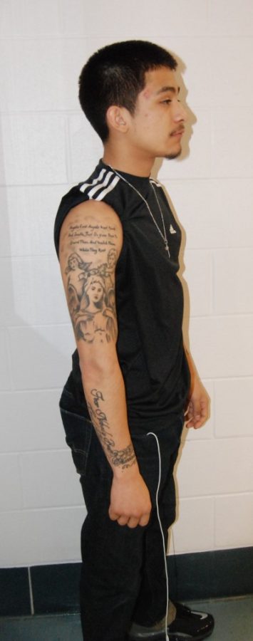 Senior Eddie Hernandez models is ten tattoos, this one of angels. Hernandez got his first tattoo when he was only 15 years old. --Michelle Blassou