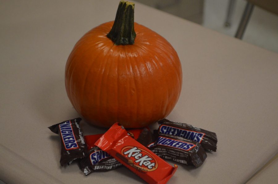 A+teachers+desk+is+showing+of+the+Halloween+spirit%2C+affixed+with+pumpkins+and+candy.+--Elissa+Britt