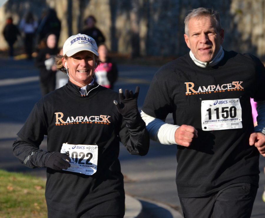 RHS Principal Billie-Jean Bensen and runner Don Marette race by. Bensen ranked 71 out of a total of 163 total runners that were ranked.