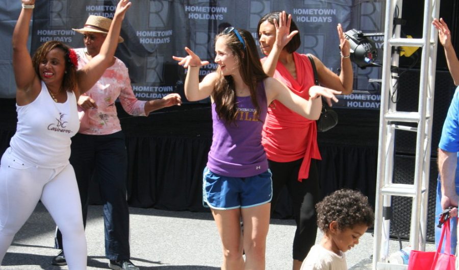 Junior Erin Johnson dances with a Latino dance crew in the middle of Rockville Town Square at Hometown Holidays. She participated in a line dance. --Sarah Wagner