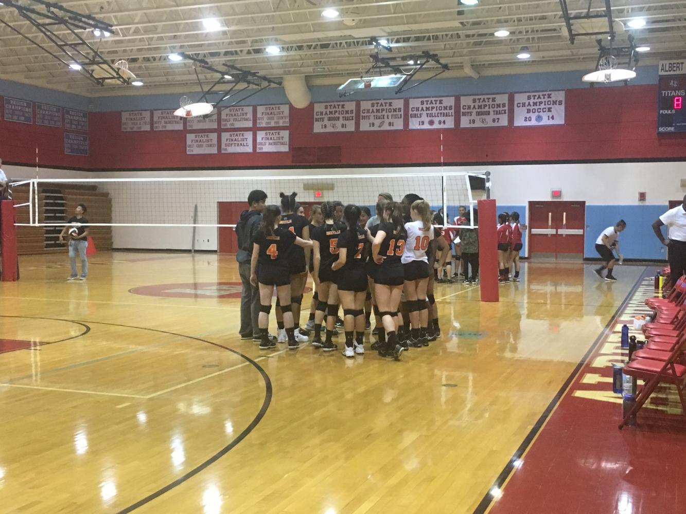 Rams huddle during a timeout against the Albert Einstein Titans whom they beat in straight sets for their first win of the season.