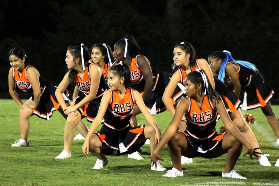 The poms team pose in formation during their halftime performance. 