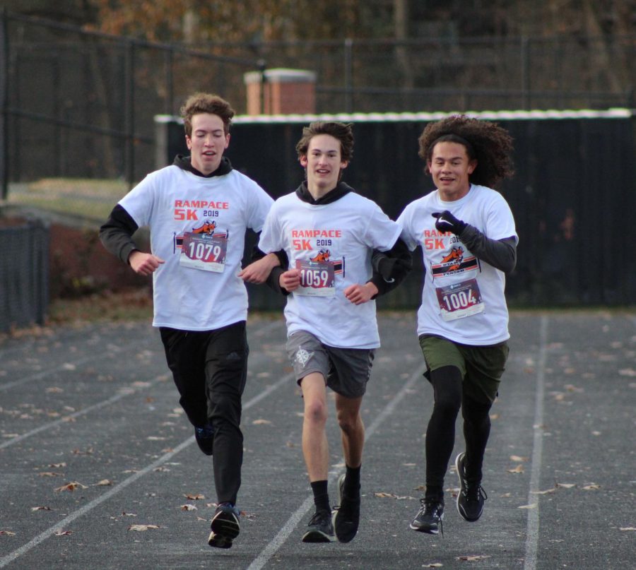 From left to right: cross country teammates senior Michael Carvajal, junior Joe Young and senior Dylan Kim linked arms through the finish line. All three of them have run the Rampace every year of their high school careers.