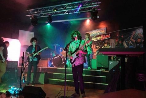 Junior Bobby Fellman, one of the founding members of the band, sings lead at a live show as his bandmates play the bass, guitar and drums behind him. The group has performed all over the greater D.C. metropolitan area at a variety of venues.