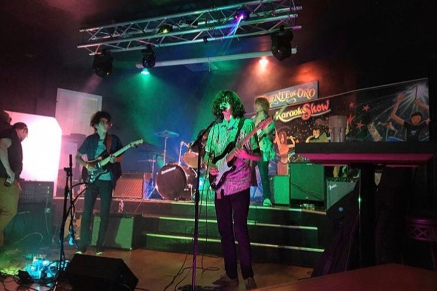 Junior Bobby Fellman, one of the founding members of the band, sings lead at a live show as his bandmates play the bass, guitar and drums behind him. The group has performed all over the greater D.C. metropolitan area at a variety of venues. 