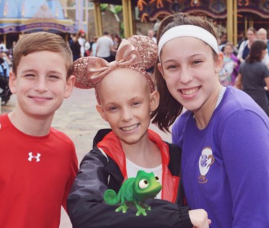 From left to right: Frank Weaver, Lily Weaver and Grace Weaver pose together at Disney World 