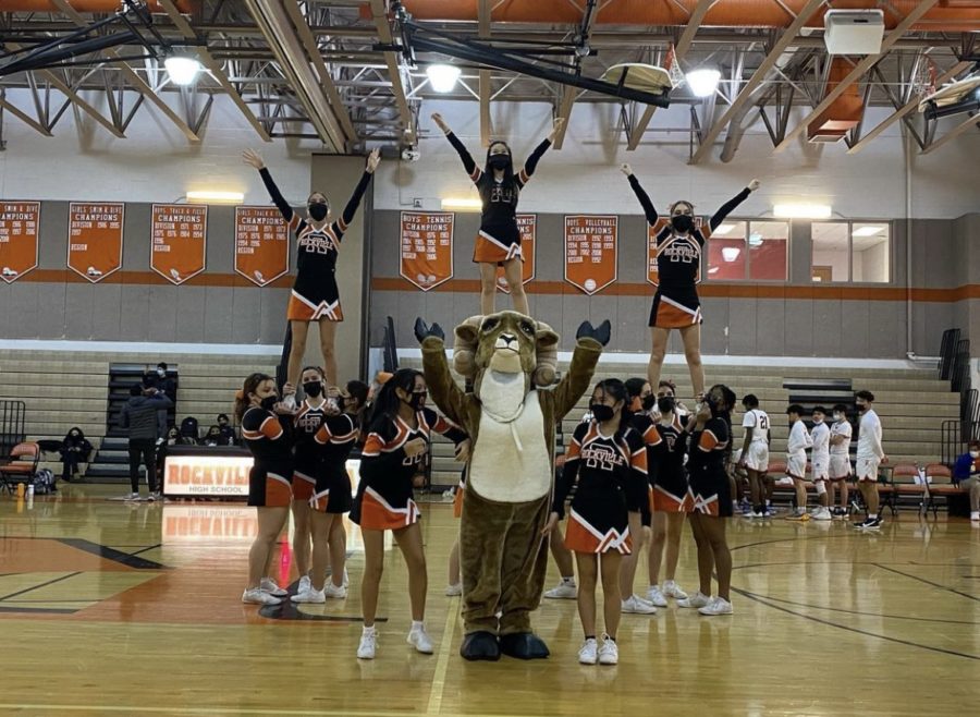 The RHS cheerleaders with their mascot, Rammy, perform a stunt following safety protocols.