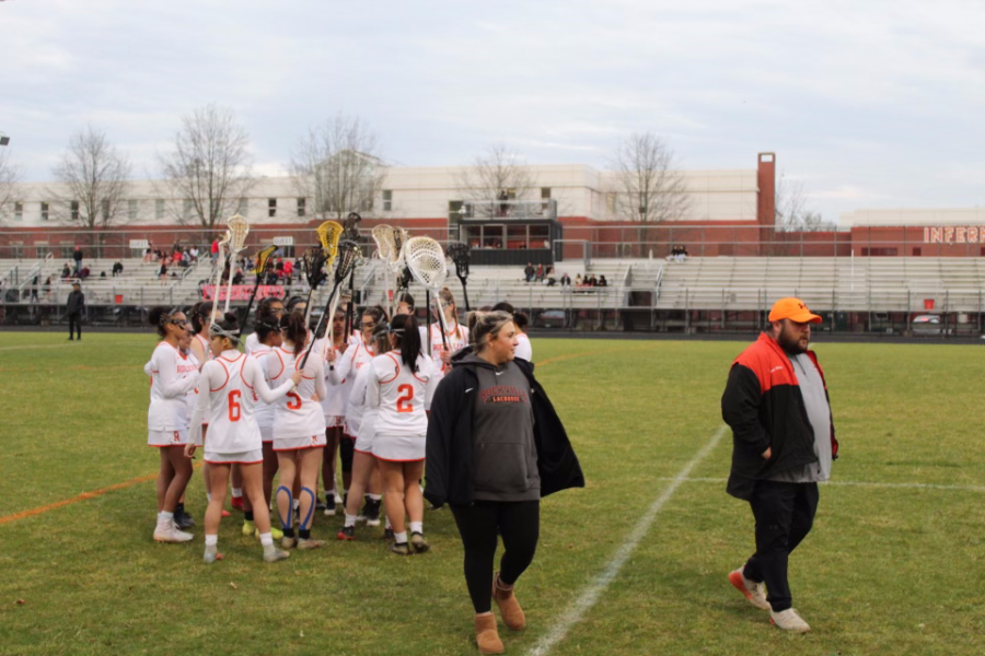 Will and Molly Morris walk off the field as Varsity Girls Lacrosse cheers before a game.
